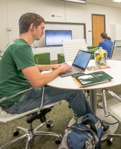 An MSU student uses a laptop in a study room on campus.
