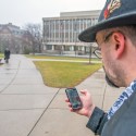 Image of man on campus with mobile phone