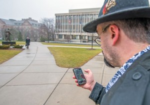 Image of man on campus with mobile phone